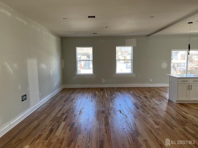 interior space with visible vents, wood finished floors, and baseboards