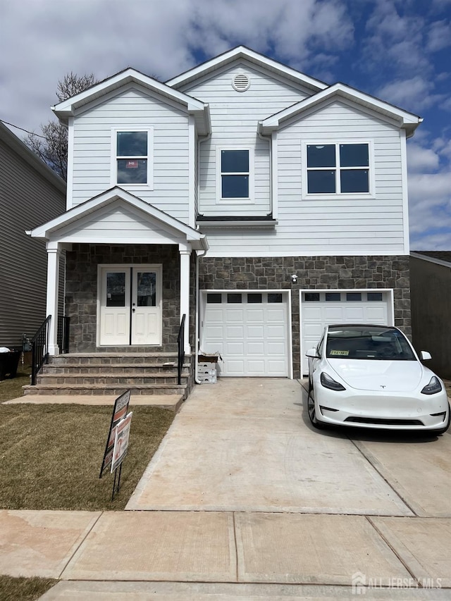 view of front of house featuring stone siding, driveway, and an attached garage