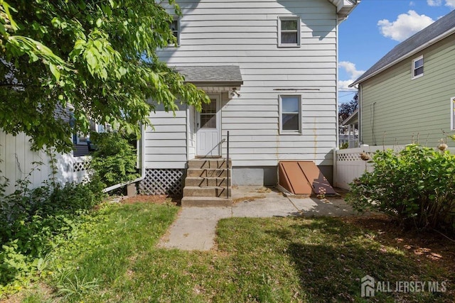 back of property with entry steps and fence