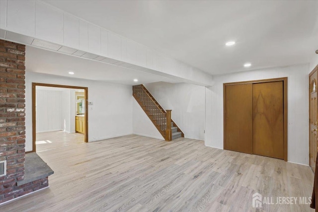 finished basement featuring stairs, recessed lighting, visible vents, and wood finished floors