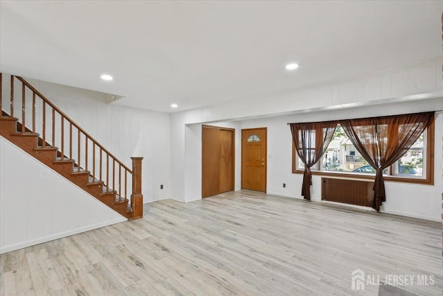 unfurnished living room featuring baseboards, stairway, recessed lighting, and wood finished floors