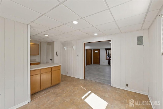 interior space featuring a drop ceiling, visible vents, baseboards, light countertops, and recessed lighting