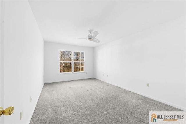 spare room featuring carpet, visible vents, baseboards, and ceiling fan