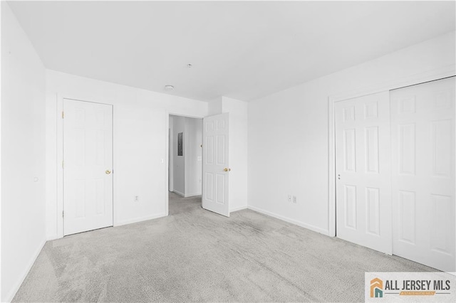 unfurnished bedroom with a closet, carpet flooring, and baseboards