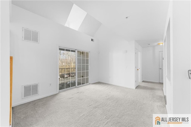 empty room with carpet, visible vents, vaulted ceiling, and baseboards