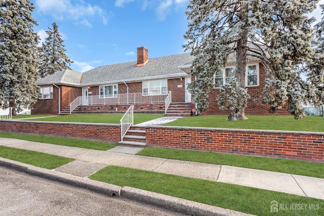 72-74 Sabo St, Carteret, NJ 07008 - view of front facade featuring a chimney, brick siding, a front yard, a shingled roof, and a porch