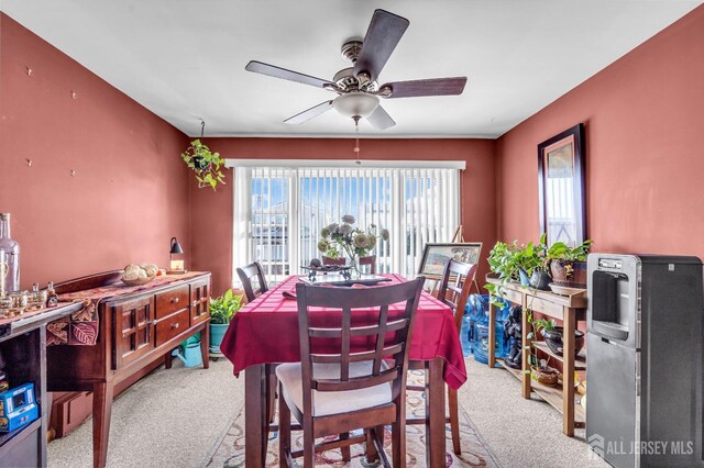 carpeted dining area featuring ceiling fan