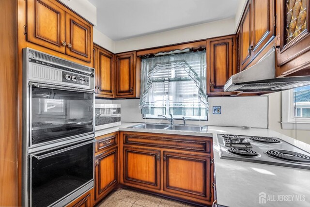 kitchen featuring light tile patterned flooring, stainless steel appliances, and sink