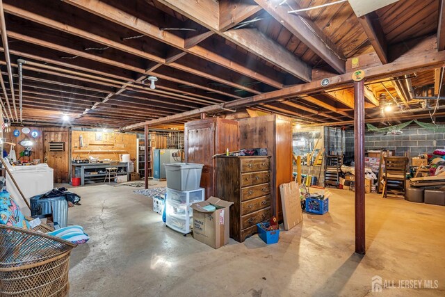 basement featuring washer / clothes dryer and fridge