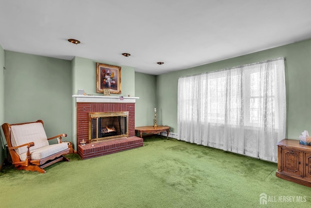 sitting room with carpet flooring, a baseboard heating unit, and a brick fireplace