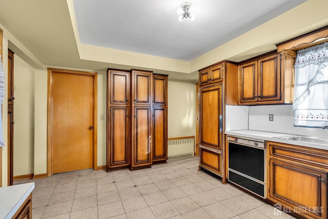 72-74 Sabo St, Carteret, NJ 07008 - kitchen with dishwasher, a sink, brown cabinets, light countertops, and baseboards