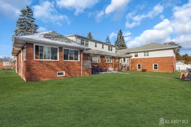 rear view of property with a yard