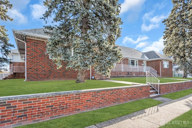 72-74 Sabo St, Carteret, NJ 07008 - view of front of house featuring brick siding, a front yard, and roof with shingles