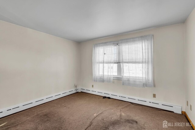 empty room featuring carpet and a baseboard heating unit