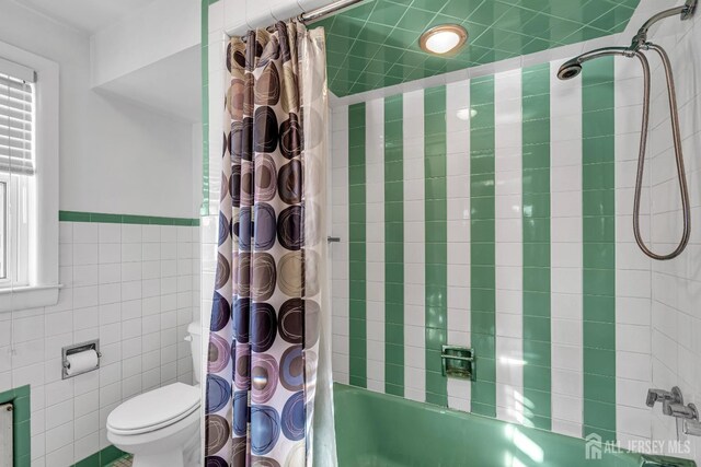 bathroom with shower / tub combo with curtain, tile walls, and toilet