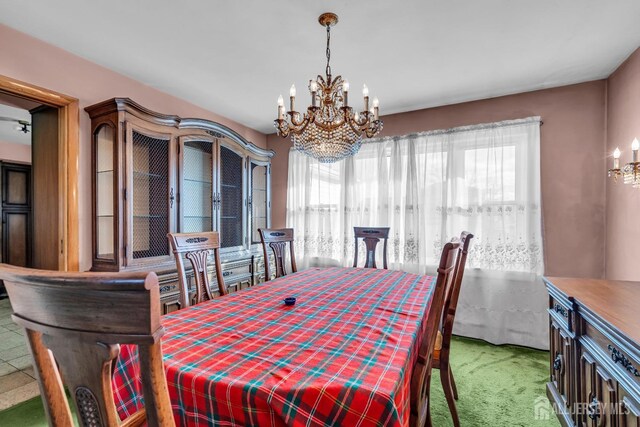 dining room with a chandelier and light colored carpet