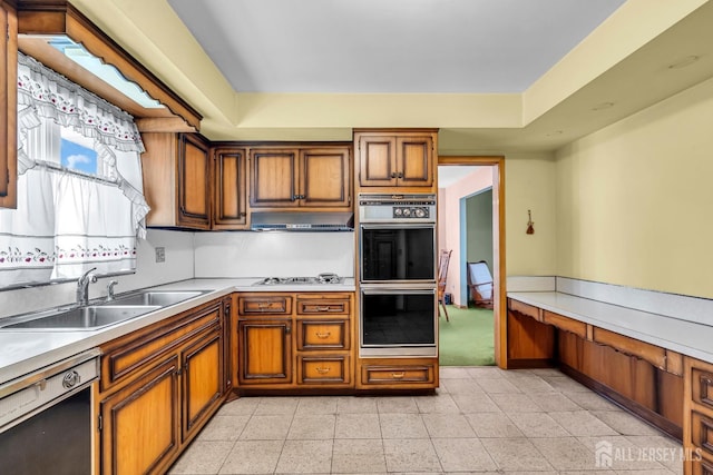 72-74 Sabo St, Carteret, NJ 07008 - kitchen featuring dishwashing machine, a sink, brown cabinetry, under cabinet range hood, and light countertops