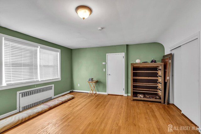 interior space featuring radiator heating unit and hardwood / wood-style floors