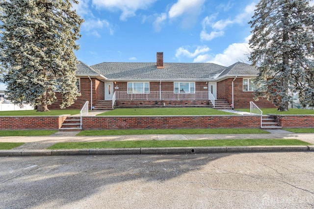 72-74 Sabo St, Carteret, NJ 07008 - view of front facade featuring a chimney, brick siding, and a front lawn