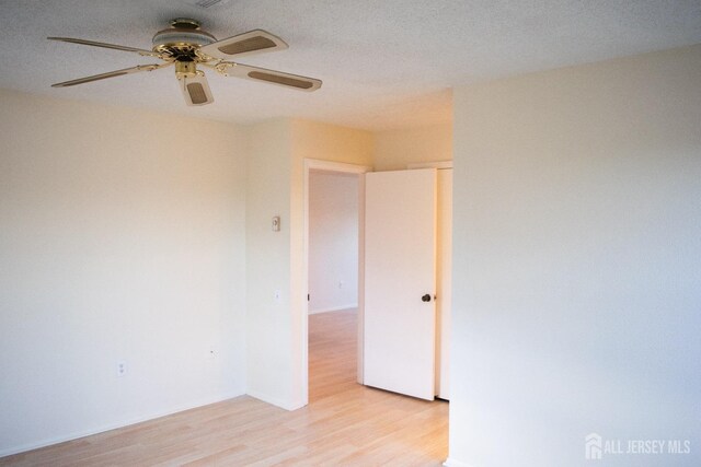 spare room featuring a textured ceiling, ceiling fan, and light hardwood / wood-style flooring