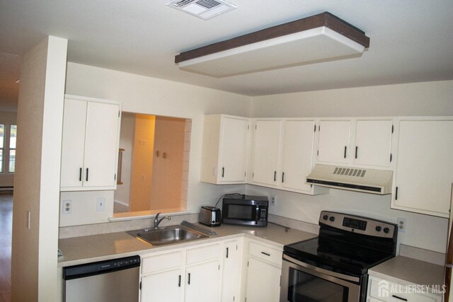 kitchen featuring sink, stainless steel appliances, white cabinets, and a baseboard radiator