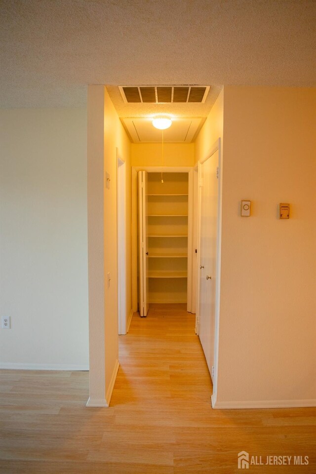 corridor with light hardwood / wood-style floors