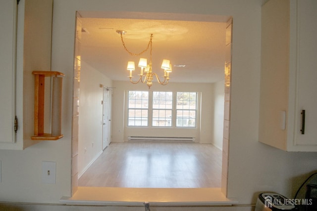 unfurnished dining area with an inviting chandelier and a baseboard radiator