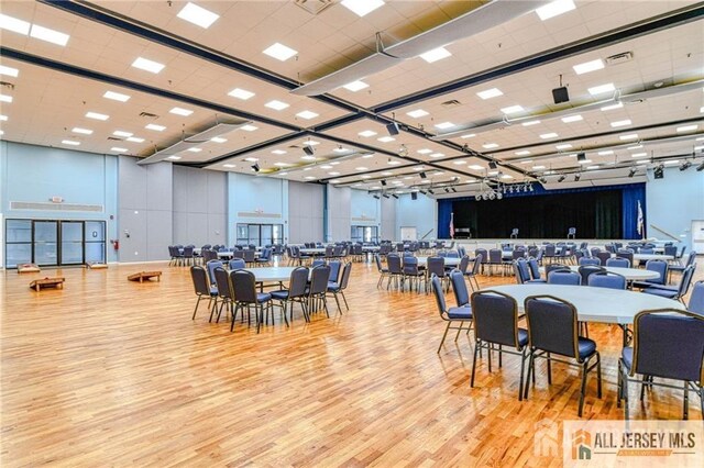 dining area featuring light wood-type flooring and a towering ceiling