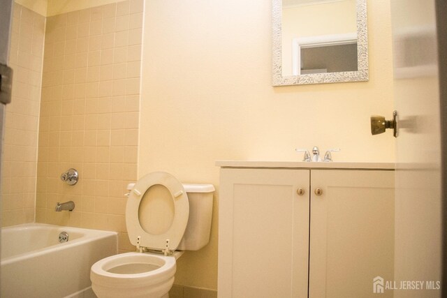 full bathroom with toilet, vanity, and tiled shower / bath combo