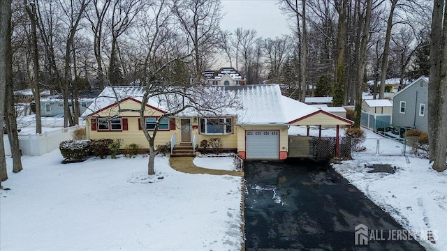 ranch-style house with fence, driveway, and a garage