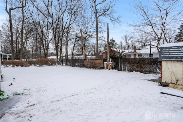 yard covered in snow featuring fence