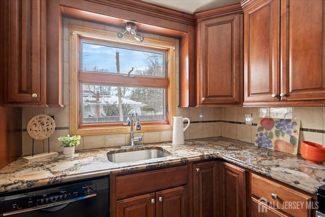 kitchen with black dishwasher, light stone countertops, a sink, and tasteful backsplash