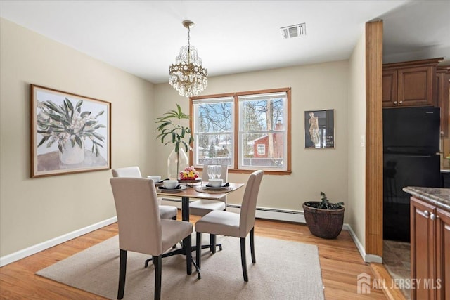 dining area featuring a chandelier, light wood-style flooring, baseboards, a baseboard radiator, and visible vents