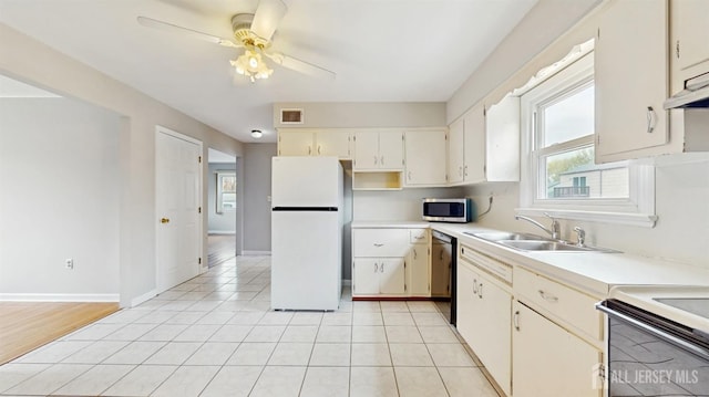 kitchen featuring freestanding refrigerator, light countertops, stainless steel microwave, a sink, and dishwasher