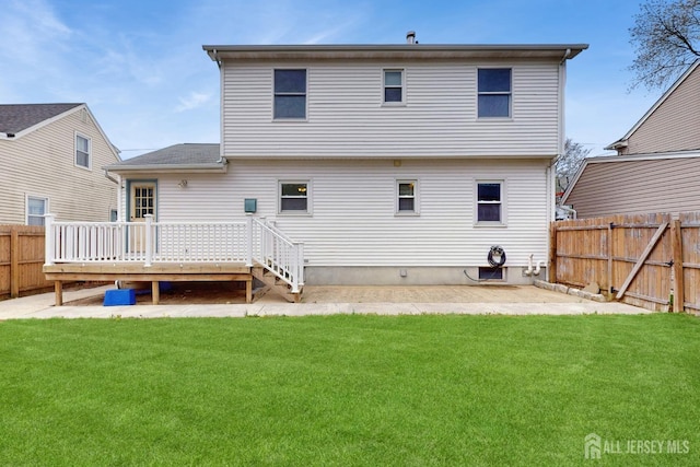 rear view of property featuring a fenced backyard, a wooden deck, and a yard