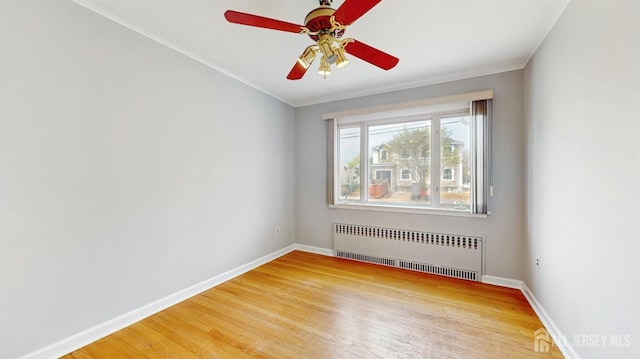 empty room featuring radiator, baseboards, a ceiling fan, and light wood finished floors