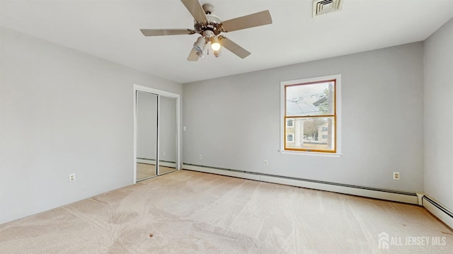 unfurnished bedroom with visible vents, a baseboard radiator, a ceiling fan, and carpet flooring