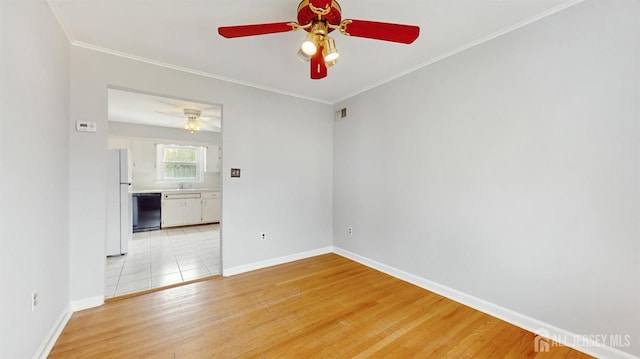 unfurnished room with baseboards, ceiling fan, ornamental molding, and light wood-type flooring