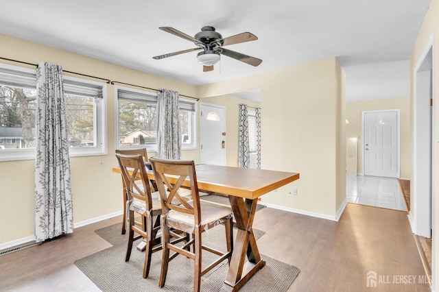 dining room with ceiling fan, wood finished floors, and baseboards