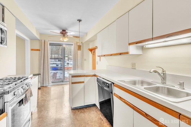 kitchen featuring appliances with stainless steel finishes, light countertops, a sink, and a peninsula