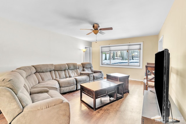 living room featuring light wood finished floors, ceiling fan, and baseboards