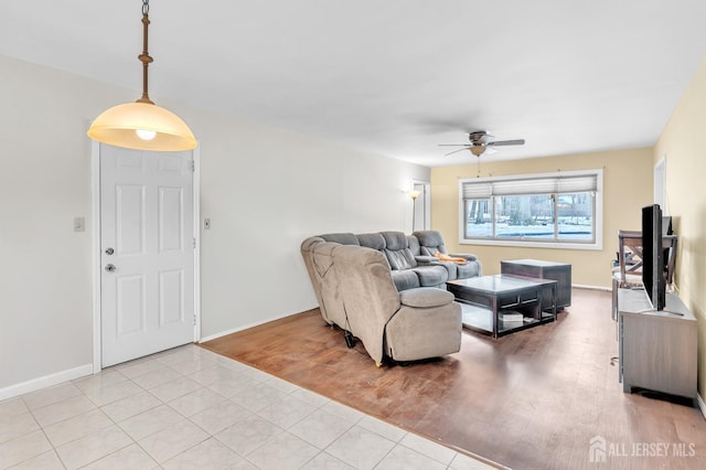 living room featuring light wood-style floors, ceiling fan, and baseboards