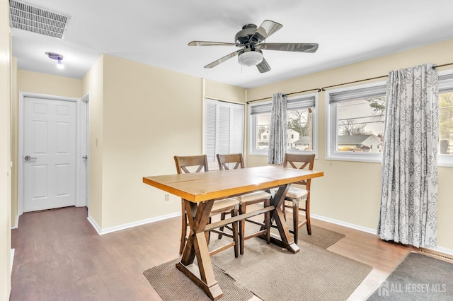 dining space featuring baseboards, plenty of natural light, visible vents, and wood finished floors