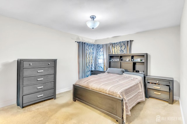 bedroom with light colored carpet and baseboards