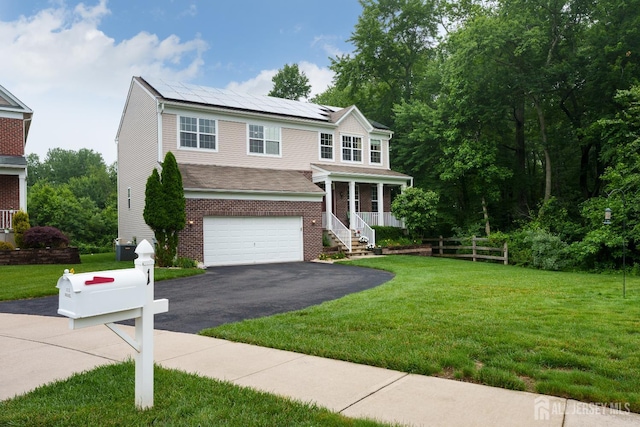 1 Elmcrest Ct E, Monroe, NJ 08831 - view of front of house with driveway, roof mounted solar panels, an attached garage, a porch, and a front yard