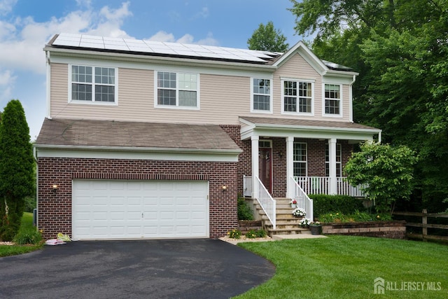 1 Elmcrest Ct E, Monroe, NJ 08831 - view of front of home featuring a garage, asphalt driveway, brick siding, covered porch, and roof mounted solar panels
