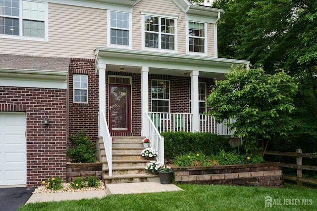 1 Elmcrest Ct E, Monroe, NJ 08831 - view of exterior entry featuring brick siding, covered porch, and a garage