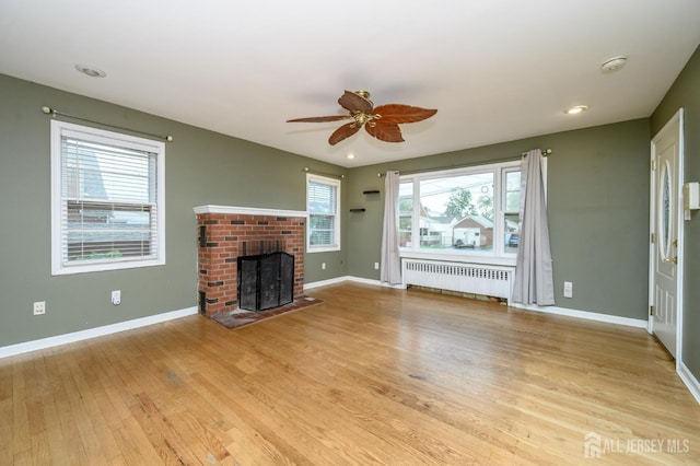 4 Ashwood Pl, North Brunswick, NJ 08902 - unfurnished living room with radiator, a ceiling fan, light wood-type flooring, baseboards, and a fireplace