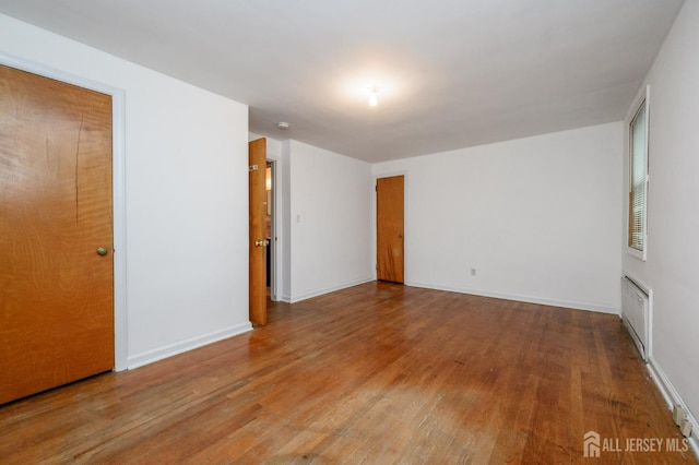 4 Ashwood Pl, North Brunswick, NJ 08902 - spare room with wood finished floors, radiator heating unit, and baseboards
