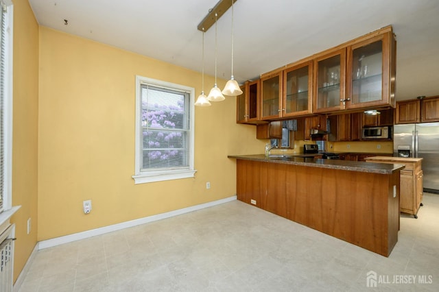 4 Ashwood Pl, North Brunswick, NJ 08902 - kitchen with appliances with stainless steel finishes, brown cabinets, glass insert cabinets, a peninsula, and pendant lighting